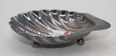 Lot 328 - A George V silver shell shaped butter dish on...