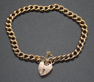 Lot 485 - A 9ct gold curblink bracelet, with heart...