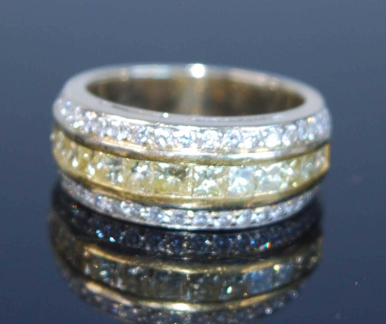 Lot 2677 - A yellow metal fancy yellow diamond three-row...