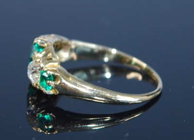 Lot 2357 - A yellow metal, emerald and diamond five stone...
