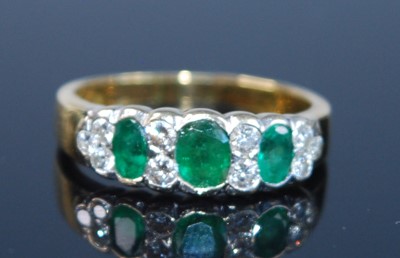 Lot 2353 - A yellow metal, emerald and diamond half...