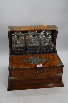 Lot 110 - An early 20th century oak cased three decanter...