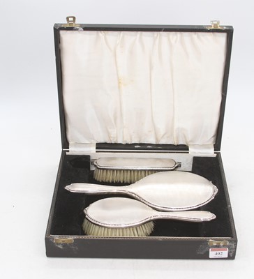 Lot 402 - An Elizabeth II silver backed three-piece...