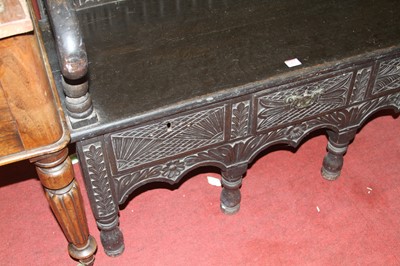 Lot 1423 - An ebonised, joined, and relief carved oak...