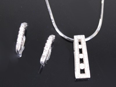 Lot 2349 - A white metal diamond pendant and earring...