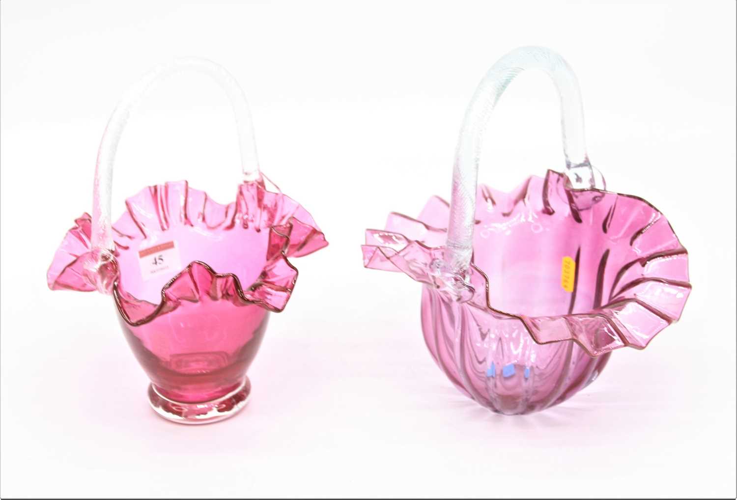 Lot 45 - A cranberry glass basket together with another,...