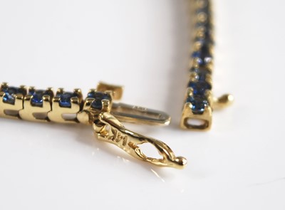 Lot 2551 - A yellow metal sapphire line bracelet...