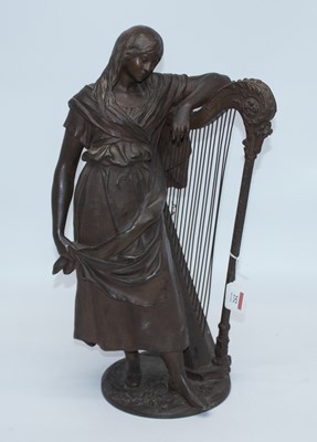 Lot 252 - A bronzed metal figure of a lady beside a harp,...