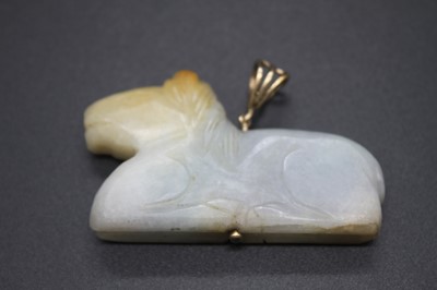 Lot 403 - A Chinese carved pale celadon and russet jade...