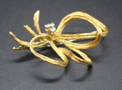 Lot 412 - A modern yellow metal and diamond ribbon...