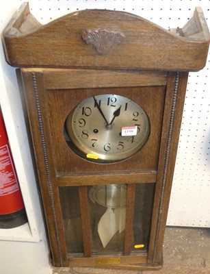 Lot 1198 - An early 20th century oak droptrunk wall clock,...