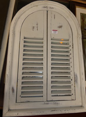 Lot 1282 - A rustic painted wood arched wall mirror, with...