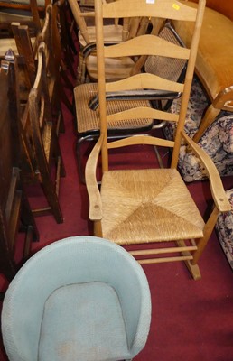 Lot 1420 - A light oak rush seat ladderback rocking...