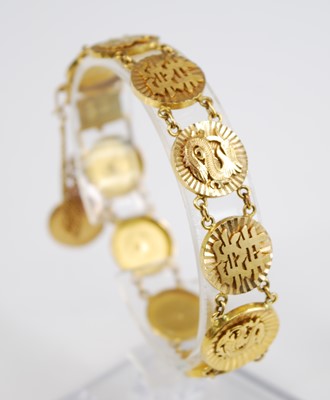 Lot 2396 - A yellow metal Asian bracelet, comprising ten...