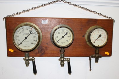 Lot 703 - A wall mounted display of three brass pressure...
