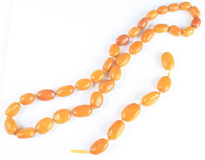 Lot 2578 - A butterscotch amber single knotted string...