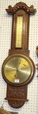 Lot 1165 - A relief carved oak two-dial wheel barometer