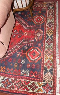 Lot 1186 - A Persian woollen red ground Shiraz rug, with...