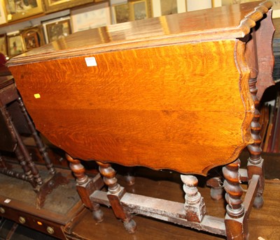 Lot 1260 - A 1930s oak piecrust topped drop leaf gateleg...