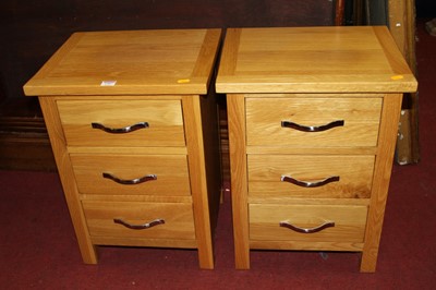 Lot 1307 - A pair of contemporary light oak three-drawer...