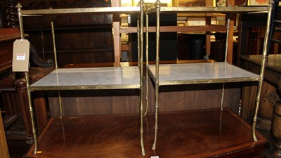 Lot 1310 - A pair of brass two-tier side tables in the...