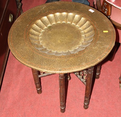Lot 1425 - An Eastern engraved brass circular topped...