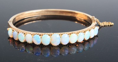 Lot 2148 - A rose metal opal oval hinged bangle, with box...