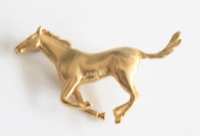 Lot 2177 - A 9ct yellow gold galloping horse brooch, with...