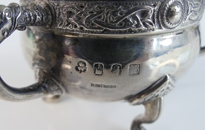 Lot 88 - An Irish Arts & Crafts silver miniature tyg,...
