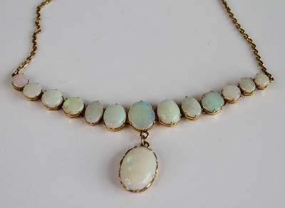 Lot 2149 - A yellow metal opal necklace, featuring 13...