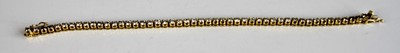 Lot 2202 - An 18ct yellow gold diamond tennis bracelet,...