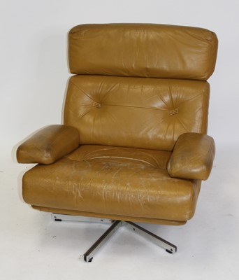 Lot 1372 - A 1960s tan leather swivel open armchair,...