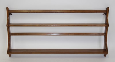 Lot 1395 - An Ercol light elm two-tier wall mounted open...