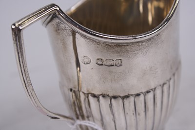 Lot 250 - A George V silver cream jug, of half-reeded...