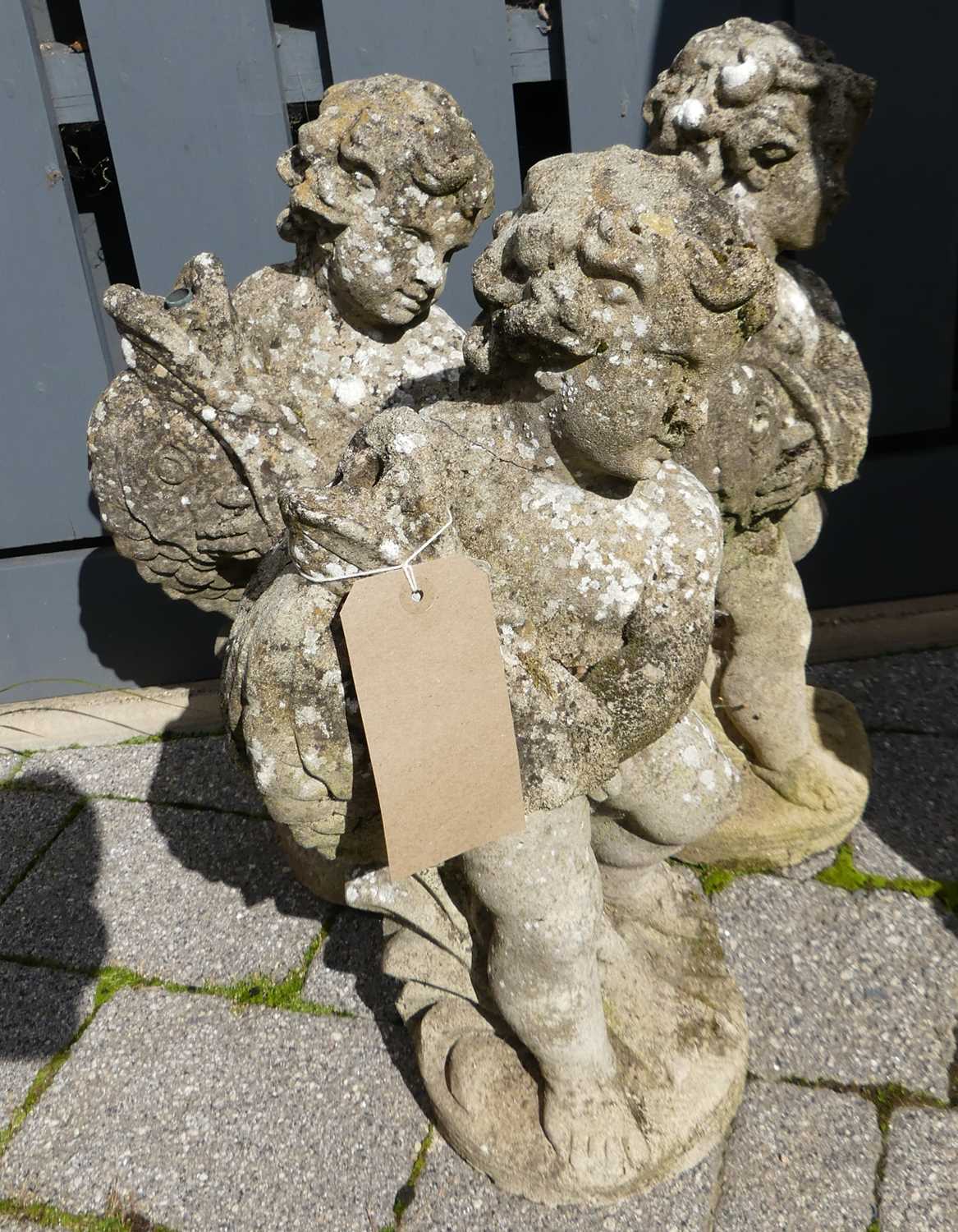 Lot 1528 - A set of three concrete cherub standing...