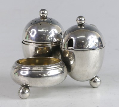 Lot 1136 - An Arts & Crafts silver three piece cruet set,...