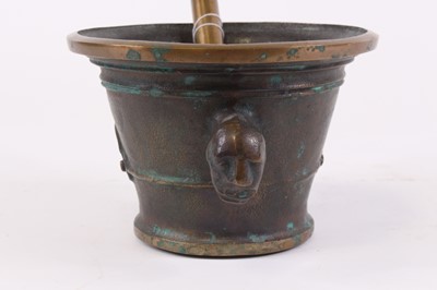 Lot 29 - A bronze pestle and mortar, the mortar flanked...