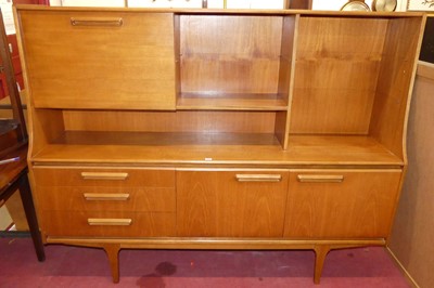 Lot 1137 - A 1970s teak highboard having open...