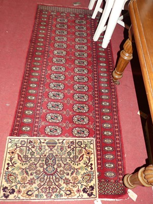 Lot 1150 - A Persian woollen red ground Bokhara hall...