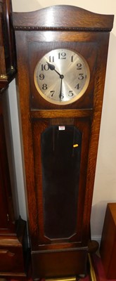 Lot 1161 - A 1930s oak longcase clock, having a silvered...