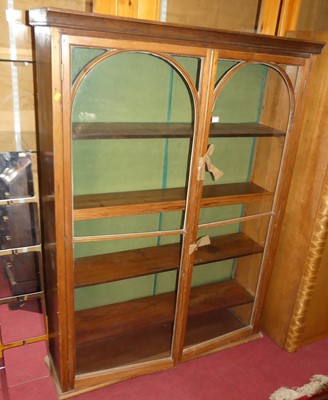 Lot 1171 - A stained pine double door glazed bookcase,...