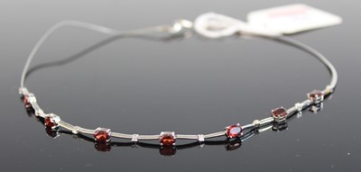 Lot 354 - A modern white metal garnet and white sapphire...