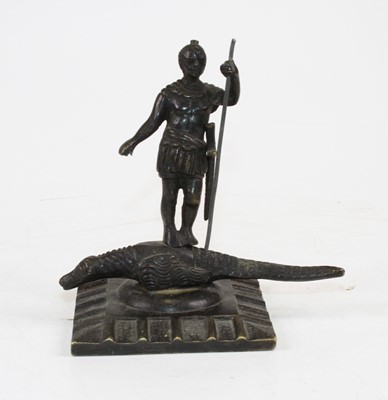 Lot 240 - A bronze model of a man standing upon a...