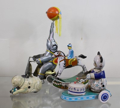 Lot 559 - A collection of four vintage tin plate toys,...