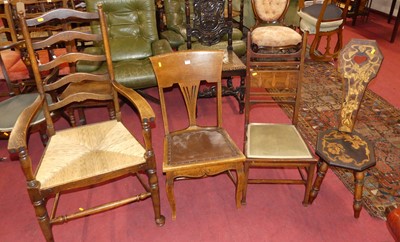 Lot 1323 - An early 20th century oak rushseat ladderback...