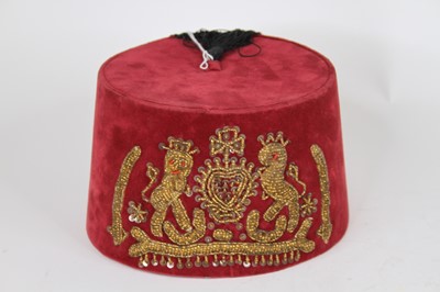 Lot 70 - A red velvet fez, embroidered with a beaded...