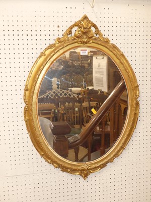 Lot 1119 - A giltwood and gesso oval wall mirror, having...