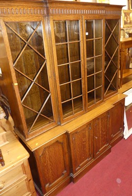 Lot 1195 - An early 20th century oak breakfront bookcase...