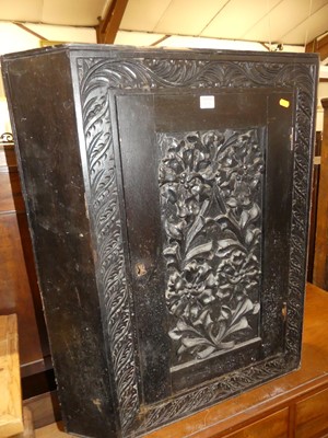 Lot 1226 - A floral carved and ebonised oak single door...