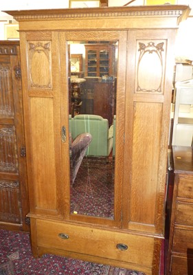 Lot 1229 - An Edwardian oak single mirror door wardrobe,...